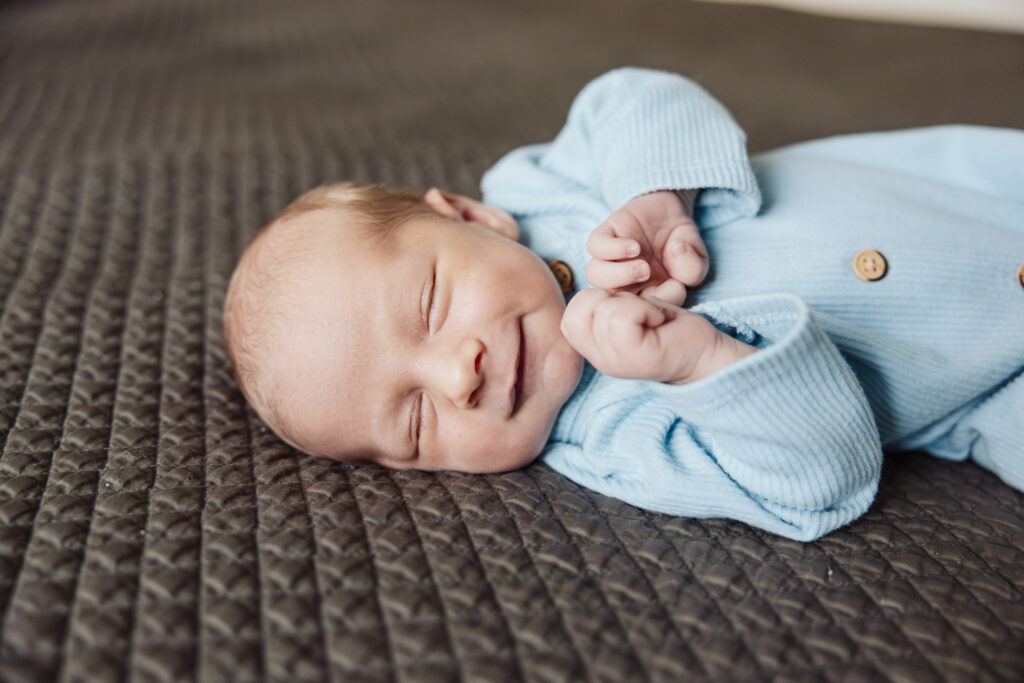 Smiling baby boy in-home newborn session in Chicago, IL by Taylor Lynn Studios