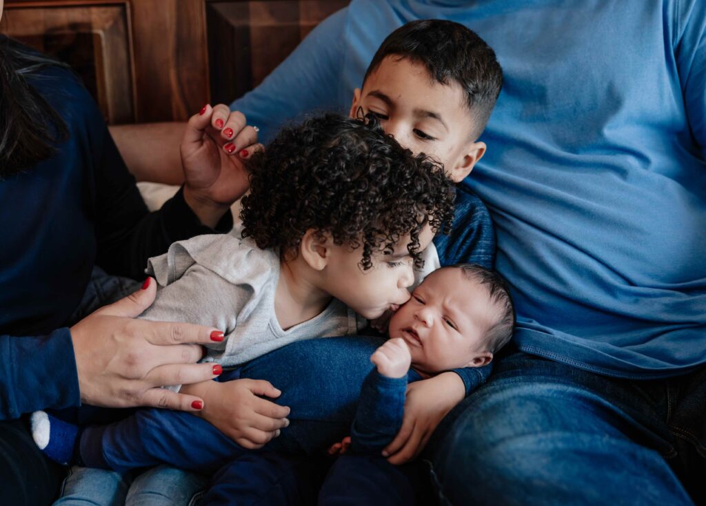 Big sister snuggling newborn in Elmhurst IL by Taylor Lynn Studios