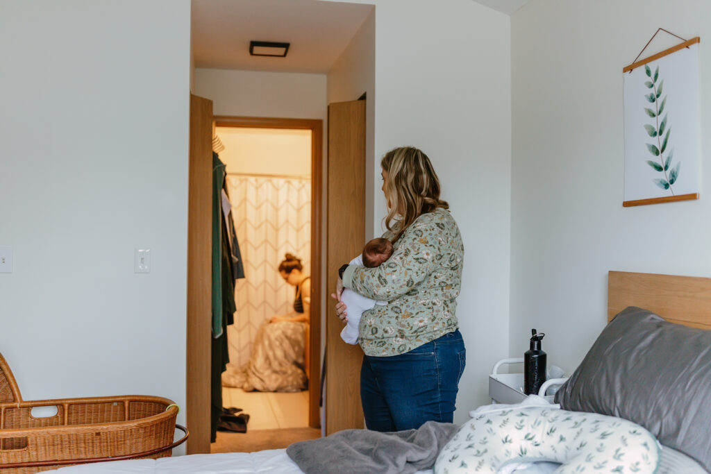 doula holding newborn for new mom in chicago il by taylor lynn studios